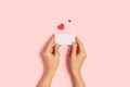 Woman hands holding blank Valentine card on pink table Royalty Free Stock Photo