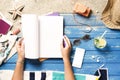 Woman hands holding blank white magazine with smart phone mockup on beach towel Royalty Free Stock Photo