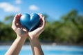 Woman hands holding a blue heart against the blue sky. Love concept Royalty Free Stock Photo