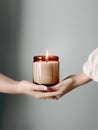 Woman hands holding burning candle, design and branding ready candle jar mockup, no face Royalty Free Stock Photo