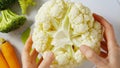 Woman hands holding cauliflower. Close-up view from above, recipe, cooking, preparation process Royalty Free Stock Photo