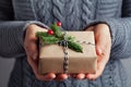Woman hands holding christmas gift or present box decorated fir tree. Cozy winter shot. Royalty Free Stock Photo