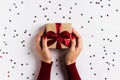 Woman hands holding christmas holiday gift box on decorated festive table