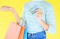 Woman hands holding credit card and holding shopping bag on yellow background - Young pretty girl happy summer shopping using a Royalty Free Stock Photo