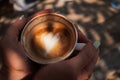 Woman hands holding cup of cappuccino coffee with heart shape. Royalty Free Stock Photo