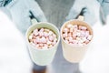 Woman Hands Holding Cup of Hot Chocolate with Marshmallow candies. Knitted mittens and Warm cocoa drink Royalty Free Stock Photo
