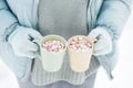 Woman Hands Holding Cup of Hot Chocolate with Marshmallow candies. Knitted mittens and Warm cocoa drink Royalty Free Stock Photo