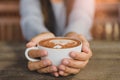 Woman hands holding cup of hot coffee latte cappuccino Royalty Free Stock Photo