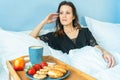 Woman hands holding a cup of hot coffee and sitting under blanket on bed Royalty Free Stock Photo