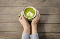 Woman hands holding cup of hot green tea with heart shaped. Royalty Free Stock Photo