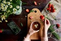 Woman hands holding cup of natural tea. Summer atmospheric table with fresh strawberries, chamomile, herbal tea, mint Royalty Free Stock Photo