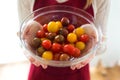 Woman hands holding different types of cherry tomatoes in round bowl at home Royalty Free Stock Photo