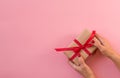 Woman hands holding gift with red ribbon Royalty Free Stock Photo