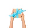 Woman hands holding gift wrapped and decorated with blue bow isolated on white Royalty Free Stock Photo