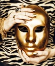 Woman hands holding golden carnival mask, rich luxury manicure and jewelry close up on zebra print Royalty Free Stock Photo