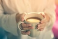 Woman hands holding hot cup of coffee or tea in morning sunlight Royalty Free Stock Photo