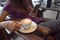 Woman hands holding hot cup coffee and using mobile smart phone in morning. girl hold warm coffee mug in cafe and checking mail. Royalty Free Stock Photo