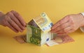 Woman hands holding house made of euro notes on table Royalty Free Stock Photo