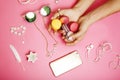 Woman hands holding macaroons with lot of girl stuff on pink background, girls accessories concept close up Royalty Free Stock Photo