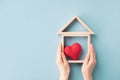 Woman hands holding model of wooden house with red heart for happy family. Real estate, sweet home, housewarming, mortgage Royalty Free Stock Photo