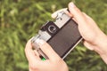 Woman hands are holding old vintage film camera outdoors. Toned. Royalty Free Stock Photo