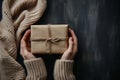 Woman hands holding present box with bow and flower