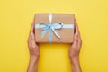 Woman hands holding present with box decorated with blue ribbon Royalty Free Stock Photo