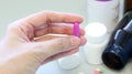 Woman hands holding a purple capsule of Clindamycin, used to treat bacterial infections, or treat patients who have an allergic.