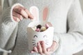 Woman hands holding rabbit box with Easter sweets inside