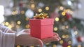 Woman hands holding red gift box presents with gold ribbon bow. Concept Season of giving, Christmas, happy new year Royalty Free Stock Photo