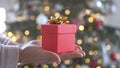 Woman hands holding red gift box presents with gold ribbon bow. Concept Season of giving, Christmas, happy new year Royalty Free Stock Photo