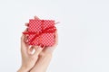 Woman hands holding red gift with ribbon, manicured hands with nail polish on white background with copy space Royalty Free Stock Photo