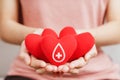 Woman hands holding red heart with blood donor sign. healthcare, medicine and blood donation concept