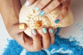 Woman hands holding sea shell and sea salt with manicured nails Royalty Free Stock Photo