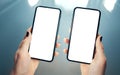 Woman hands holding side by side two smart phones. Comparing, analyzing or matching two products or services - concept. Clean and