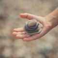 Woman hands holding small stones in hands on beach background with burning sun Royalty Free Stock Photo