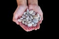 Woman hands holding small stones in hands isolated on black Royalty Free Stock Photo