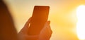 Woman hands holding smartphone at outdorrs in the evening