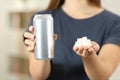 Woman hands holding a soda drink can and sugar cubes