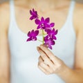 Woman hands holding some violet orchid flowers, sensual studio shot Royalty Free Stock Photo