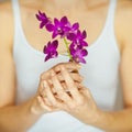 Woman hands holding some violet orchid flowers, sensual studio shot Royalty Free Stock Photo