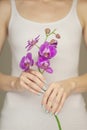 Woman hands holding some violet orchid flowers, sensual studio shot Royalty Free Stock Photo