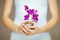 Woman hands holding some violet orchid flowers, sensual studio shot Royalty Free Stock Photo