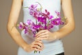 Woman hands holding some violet orchid flowers, sensual studio shot Royalty Free Stock Photo