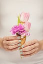 Woman hands holding spring flowers in an ice cream cone, sensual studio shot Royalty Free Stock Photo