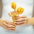 Woman hands holding spring flowers in an ice cream cone, sensual studio shot Royalty Free Stock Photo