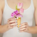 Woman hands holding spring flowers in an ice cream cone, sensual studio shot Royalty Free Stock Photo
