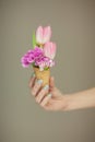 Woman hands holding spring flowers in an ice cream cone, sensual studio shot Royalty Free Stock Photo