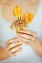 Woman hands holding spring flowers in an ice cream cone, sensual studio shot Royalty Free Stock Photo