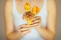 Woman hands holding spring flowers in an ice cream cone, sensual studio shot Royalty Free Stock Photo